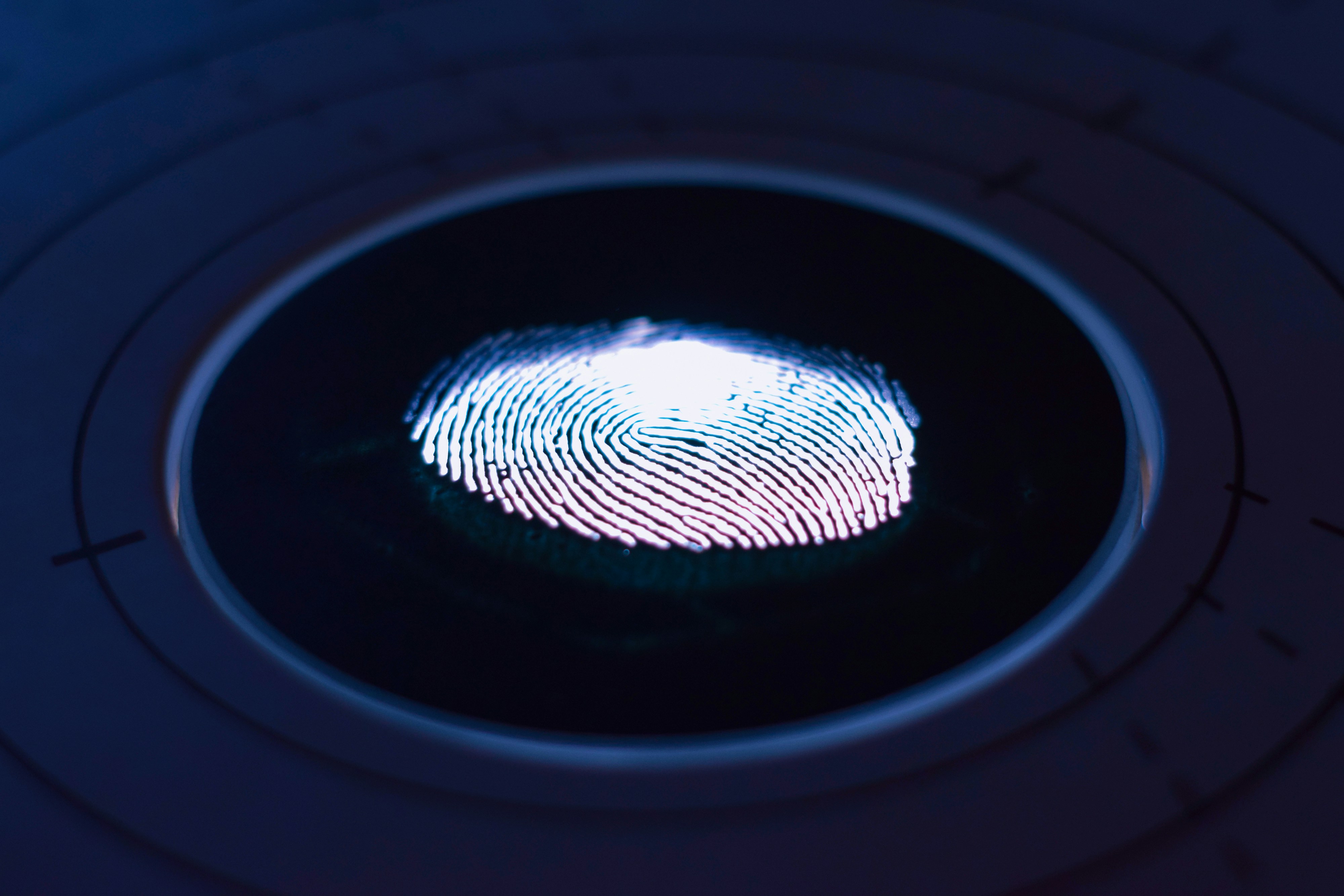 A biometric scanner capturing a fingerprint with illuminated details.