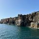 Rocky coastline of Cascais with blue water.
