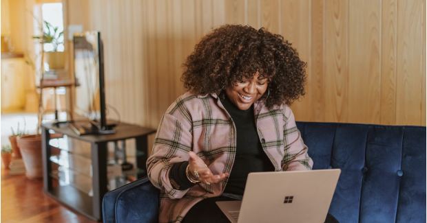 The woman is looking at the laptop