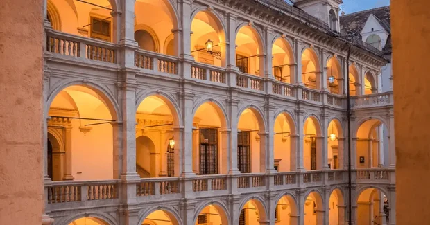 old style austrian building with many arches lit up at night
